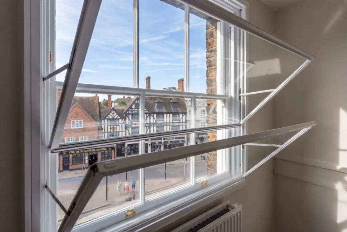 Open secondary glazing panels around a period sash window