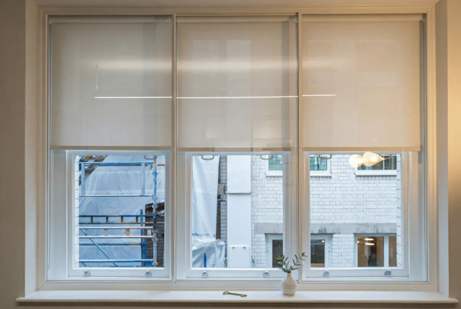 Secondary glazing across three windows with roller blinds
